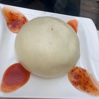 steamed Vietnamese bao bun filled with soy, glass noodles, morels, carrots, peas, sweet chili sauce, chili sauce at Vevi in Vienna