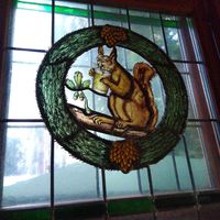 The indoors has stained glass windows including the squirrel that gives this place is name (pictured with the iconic Frankfurt cider) at Zum Eichkatzerl in Frankfurt