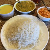 String Hoppers (white rice noodles). Served with Coconut Milk Curry (left), Dhal Curry (middle) & Coconut Sambol (right). It's like a stack of tortillas that you load, roll & eat. at House of Curry in Rosemount