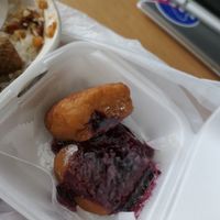 Fried Square of Dough topped with Powdered Sugar and Raspberry Sauce at Stango Cuisine in Champaign