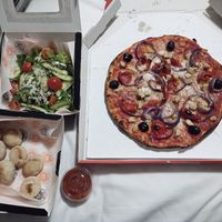 Salad, dough balls, vegan Pollo ad Astra with olives, and a pot of marinara sauce at Milano in Swords