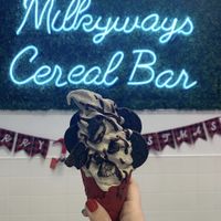 Vegan vanilla with cookie butter and Oreos mixed in. Oreos and Hershey’s syrup on top with a red velvet cone  at MilkyWays Ice Cream & Cereal Bar in Coram