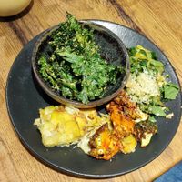 plate of vegetables with potato gratin and a bowl of dehydrated kale at Naya Studio in Paris