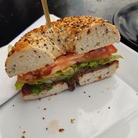 Bagel com pasta picante de feijão preto e salada. at Cortado Tasting Room in Bedford