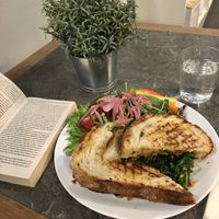 Grilled sourdough sandwich with aubergine, marinated kale, and tomato pesto. at Cortado Coffee Shop in Halmstad