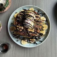 Pancakes aux pépites de chocolat et banane avec crème chantilly à la noix de coco et sirop d'érable at Sham - Mont Royal in Montreal