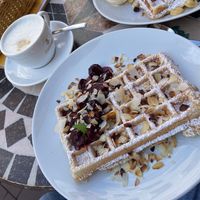 Waffle with marzipan, warm cherries and almonds and oat cappuccino  at Kleines Waffelhaus in Luebeck