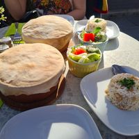 Vegan vegetable stew baked served in a stone bowl with the bread baked on top of the bowl, rice and a small mixed salad at Seran in Bad Harzburg