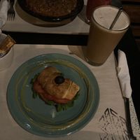 Medialuna con muzzarella vegana, tomate, rúcula y aceitunas negras. Café frío con leche de almendras.  at Casa Bruja in Montevideo