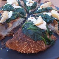 Vegan pizza with corn dough, topping: spinach, artichoke, cashew cheese at Fetiche in Ljubljana