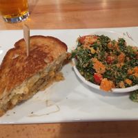 A half eaten Reuben with a side peanut kale salad. at Seva - Ann Arbor in Ann Arbor