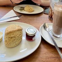 Vegan scone, cream, jam and hot chocolate in foreground.  at The Greenwood Tree in Lyndhurst