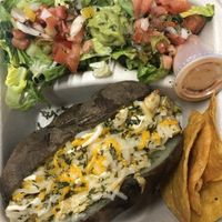 Papa asada rellena de “pollo” y “queso” acompañado de ensalada y chips at La Zanahoria in Bayamon