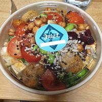 Quinoa, salad, tofu, falafel, crunchy chickpeas, tomatos, edamame, beetroot, and seed topping with sesame-ginger dressing at Jawz The Bowl Company in Munich