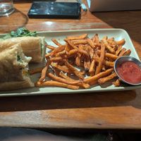 Partially eaten banh mi and sweet potato fries at Raven Cafe in Prescott