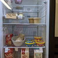 The fridge--yogurt parfait, soup, sandwiches, hummus, creamer, and milks at Jinglepear Deli - Online only in Toronto