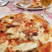 Pizza rossa con mozzarella di riso, olive taggiasche e funghi at Pizzaria Peperetta Dispetusa in Imperia