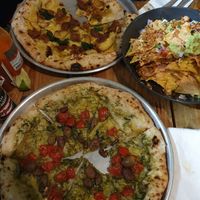 Nachos, pesto and pomodoro pizza, potato and sausage pizza at Plant Base in Lisbon
