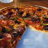 Pizza with tomato sauce, green peppers, onions, olives and oregano at Fanalino Restaurant Bar in Paxos