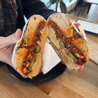 Red dwarf - sundried tomato pesto, hummus, pickles on an everything bagel. Recommended by staff for the top notch hummus. Great flavors!  at Beam Me Up Bagels - City in Dunedin
