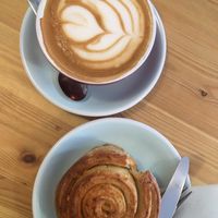 Latte with oat milk and vegan lemon roll at Malabarista Cafe in Lisbon
