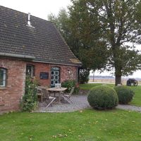 Außenansicht (hinterm Haus ist ein großer Bereich mit Strandkörben zum Sitzen) at Koog Café in Wesselburenerkoog