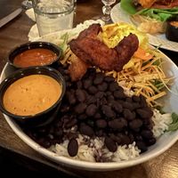Pow pow pow bowl with curtido, spicy white onions, tortilla strips, and maduros. Side of al pastor sauce and sunflower chipotle sauce.  at Hermanas Kitchen and Cocktails in Lindenhurst