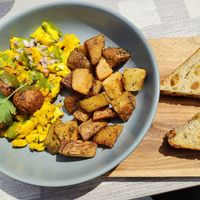 Hangry Panda  $18  |  tofu scramble, potatoes with cilantro cumin sauce, vegan mushroom Thai Sausage, fennel raisin toast at Monarch in Brooklyn
