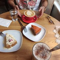 Strawberry-rhubarb cake (left), chocolate-orange raw cake (right), cappuccino & chai latte with oat milk at Kahvila Oskari in Lahti