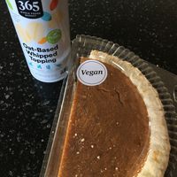 Vegan half pumpkin pie with plant-based whipped topping for dessert. at Whole Foods Market - St Paul in St Paul