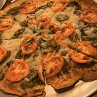 12" (one size) build-your-own pizza with vegan cheese, cracker crust, basil pesto sauce, tomatoes, garlic and jalapeños  at Peddlers Pizza Pub in Valparaiso