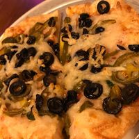 Personal Pan pizza w vegan cheese, black olives, jalapeños and spinach  at Peddlers Pizza Pub in Valparaiso