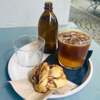 Vegan cinnamon roll, espresso tonic and a bottle of water  at SUEDHANG in Tubingen