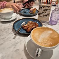 Two lattes, sweet pastry and blueberry cheesecake at Kafé Plattan in Stockholm
