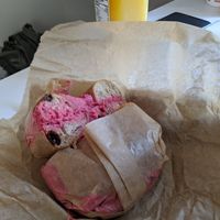 Cross section of a cinnamon raisin bagel (not vegan, honey) with beet hummus spread at Bagelsaurus in Cambridge