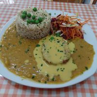 Split pea stew, rice, salad, protein with huancaína sauce at Good Karma in Lima