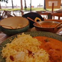 Arroz con azafrán y pasas con albóndigas de carne vegetal y patatas en sala de tomate. at Cinnamon in Sitges