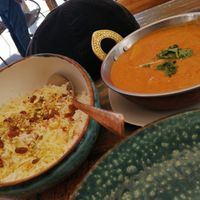 Arroz con azafrán y pasas con albóndigas de carne vegetal y patatas en sala de tomate. at Cinnamon in Sitges