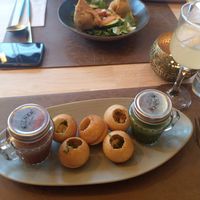 Pani puri, described on the menu as India's favourite street food: puffed dough balls filled with seasoned mashed potatoes and vermicelli served with a dash of tamarind and cumin m at Garlic n Greens in Bruges