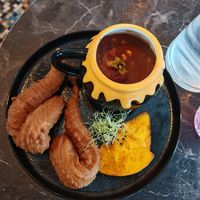 Gluten-free chili sin carne, simmered red beans, onions, corn, smoked tomatoes served with corn churros and paprika-toasted pita bread. at Café Contresort in Paris