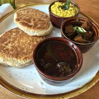 Pol Roti plus small bowls of: Parippu, Black Pork Curry, and Jaggery Beef Curry  at Mirisata in Portland