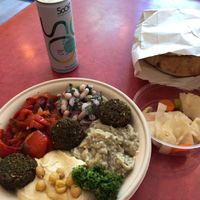 Mezze bowl: hummus, white bean salad, baba ganoush, red bell pepper, falafels and a spicy green condiment. Vegetables on the side and home-baked pita.   at Levantini in Maastricht