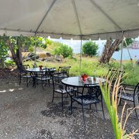There are several comfortable dining sets under a tent.   at PlantTastic in St Thomas