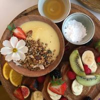 The vegan breakfast with golden smoothie bowl, banana pancakes and fresh fruit. at Sofia in Oostende