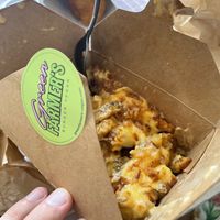 Cheesy Fries are thinly sliced potato fries loaded with a delightful cheesy sauce and topped with crispy onionns  at Green Farmer's in Paris