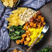 Buddha Bowl with hummus, fried tofu, sweet potato, turmeric rice, spinach salad and tortilla chips at Hrana Pământului in Timisoara