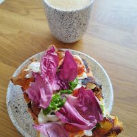 Oat latte and focaccia with tomatoes and pesto at Eter Vegan Bakery in Warsaw