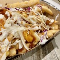 Loaded Fries “F”. Mac n’ cheese, hot sauce, aioli, white & purple cabbage, bbq sauce.  at Mad Benji in Berwick