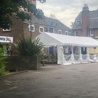 They have loads of covered seating, as well as a green space with more tables to their left and the pub inside to the right. at The Rainbow Skull in Maidstone