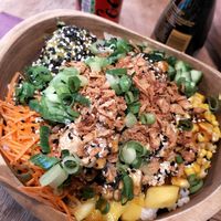 bowl with rice, salad, carrots, avocado, mango, cucumber, spring onion, crispy onion, tofu, sesame seeds and teriyaki sauce at Hawaiian Poke Bowl in Antwerpen